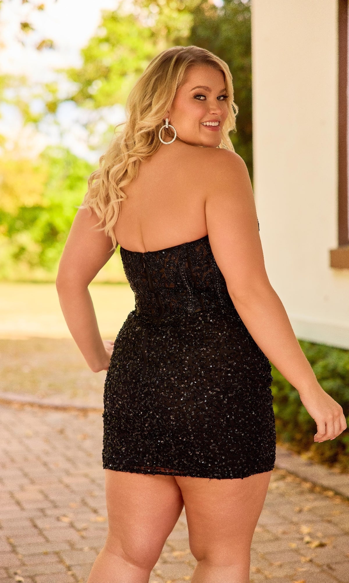 Woman wearing a black sequin dress outdoors